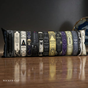 a decorative body pillow with a row of Halloween books design on a glossy wooden table.