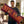 A man holding a long maroon body pillow with orange text that reads 'ENTER NIGHT' in a cozy indoor room setting. The brand name 'Wicked Cat' is visible in the bottom left corner.