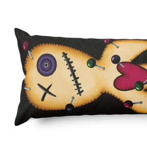 A rectangular black body pillow featuring a printed graphic of a stitched voodoo doll face in tan, with a purple button, black stitches, a pink heart, and colorful pins, shown on a white background.
