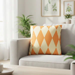 Orange and white patterned pillow on a gray sofa in a bright living room.