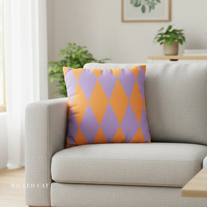 Gray sofa with a purple and orange patterned pillow in a living room setting.