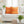 White sofa with orange patterned pillows in a living room setting.