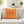 Orange diamond patterned pillow on a white sofa in a bright living room.