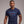 Man wearing a navy blue t-shirt with colorful text on a plain background