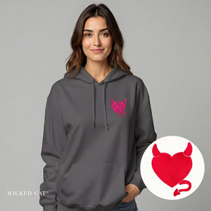 Woman wearing a gray hoodie with a pink logo on a gray background, with a red heart and devil horns icon inset.