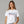 Woman wearing a white t-shirt with 'American Woman' text on a gray background