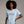 Woman wearing a light blue t-shirt with 'American Woman' text on a plain background