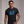 Man wearing a black t-shirt with 'Patriotic AF' design on a plain background