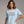 Woman wearing a light blue t-shirt with 'Semiquincentennial 1776-2026' text on a plain background