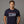 Man wearing a navy blue t-shirt with 'Seninquincentennial 1776-2026' text on a gray background