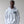 Person wearing a white hoodie with a skull graphic design on a plain background