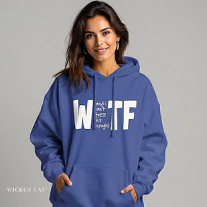 Woman wearing a blue hoodie with text, standing against a gray background