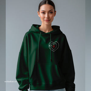 Person wearing a white hoodie with embroidered 'Grinch Funny Holiday' design on a plain background