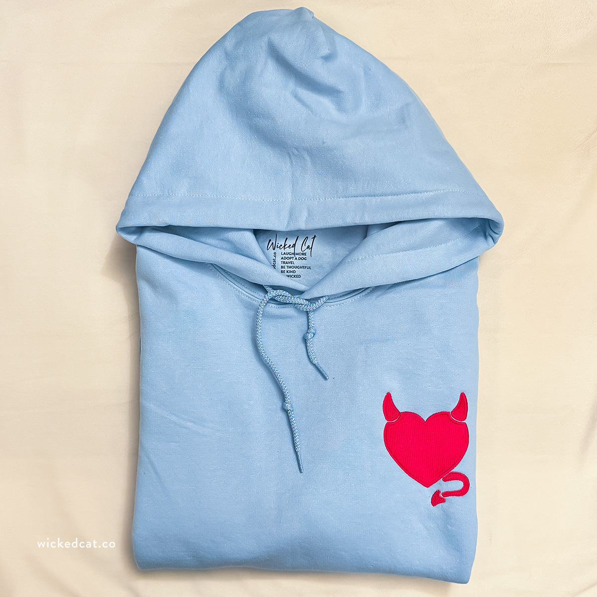 White hoodie with a red heart design on a white background