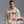 Man wearing a beige hoodie with 'START JUMPING' text, standing against a gray background.