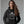 Person wearing a navy blue hoodie with 'Love Potion Perfume Witchy Halloween' design on a plain background