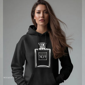 Person wearing a navy blue hoodie with 'Love Potion Perfume Witchy Halloween' design on a plain background