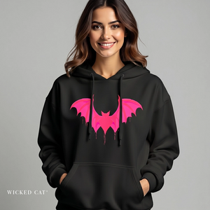 Woman wearing a black hoodie with pink bat design on a gray background