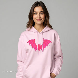 Woman wearing a pink hoodie with bat wings design on a gray background