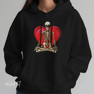 Person wearing a black hoodie with 'Namaste Skeleton Yoga Halloween' design on a plain background