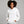 Woman wearing a white hoodie with text, standing against a gray background