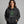 woman wearing a black sweatshirt hoodie with a graphic of a ball of tangled Christmas lights and text that says 'It's fine, this is fine, everything is fine'.