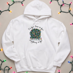White sweatshirt hoodie with a graphic of a ball of tangled Christmas lights and text that says 'It's fine, this is fine, everything is fine'.