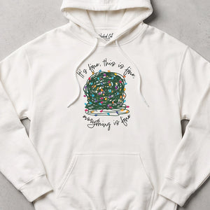 White sweatshirt hoodie with a graphic of a ball of tangled Christmas lights and text that says 'It's fine, this is fine, everything is fine'.