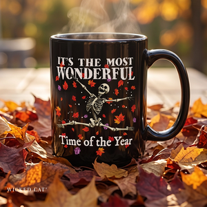mug with 'The Most Wonderful Time of the Year Halloween' graphic on a pile of fall leaves.