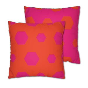 Two square decorative pillows with a reversible design featuring pink and orange hexagons on a dark background.