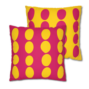 Two square throw pillows, one with a pink faux suede cover and the other with a yellow faux suede cover, both featuring a retro polka dot pattern.