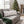 A rectangular lumbar throw pillow with a festive holiday print of red and blue martinis on a white background, styled on a gray sofa in a cozy living room with a Christmas tree in the background. The brand 'Wicked Cat' is visible in the bottom left corner.