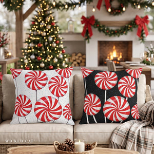 Christmas scene with two pillows on a sofa, one white with peppermints, one black with peppermints.