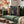 A decorative throw pillow featuring a set of gothic book spines, sits on a green sofa in a cozy living room setting.