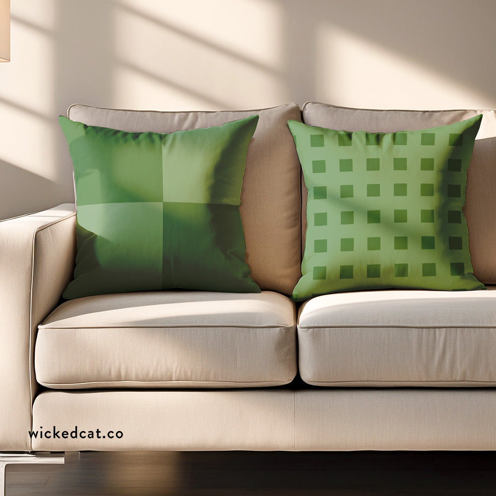Two green pillows with different geometric checkered patterns on a white background