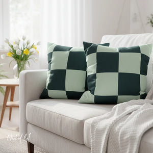 Checkered green and white cushions on a light gray sofa with a blurred background