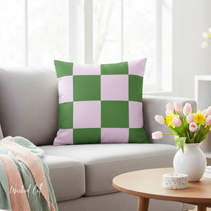 Checkered green and pink pillow on a gray sofa with a vase of tulips on a coffee table.