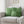 Green checkered pillows on a beige sofa in a living room setting.