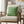 Beige armchair with a green checkered pillow in a living room setting