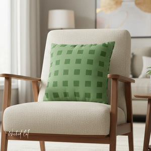 Beige armchair with a green checkered pillow in a living room setting