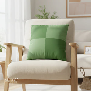 Green checkered pillow on a beige armchair in a bright room with plants and decor.