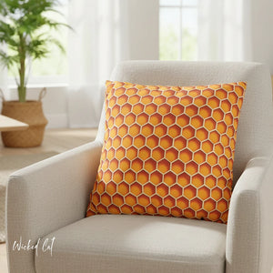 Orange hexagonal patterned pillow on a beige armchair with a blurred indoor background