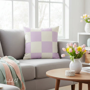 Living room with a gray sofa, checkered pillow, and a small table with flowers.