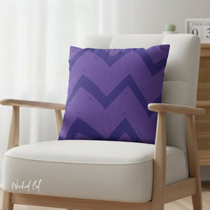 Purple zigzag patterned pillow on a white chair with a blurred background