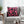 Pink and black abstract patterned pillow on a gray sofa with a coffee table in the foreground