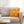 Yellow pillow with pink geometric pattern on a gray sofa in a living room setting.