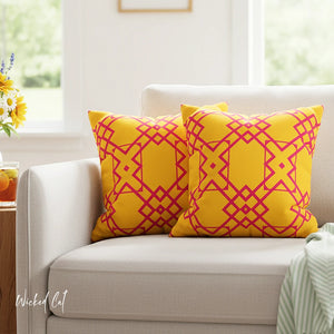 Yellow and pink patterned pillows on a white couch with a blurred background