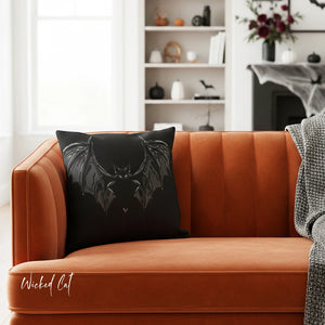 Black bat pillow on an orange couch in a living room setting