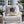 Decorative pillow with 'Bates Motel' design on a white chair outdoors.