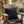 Green cat eyes on a black pillow on an outdoor chair with a dirty martini on a book.